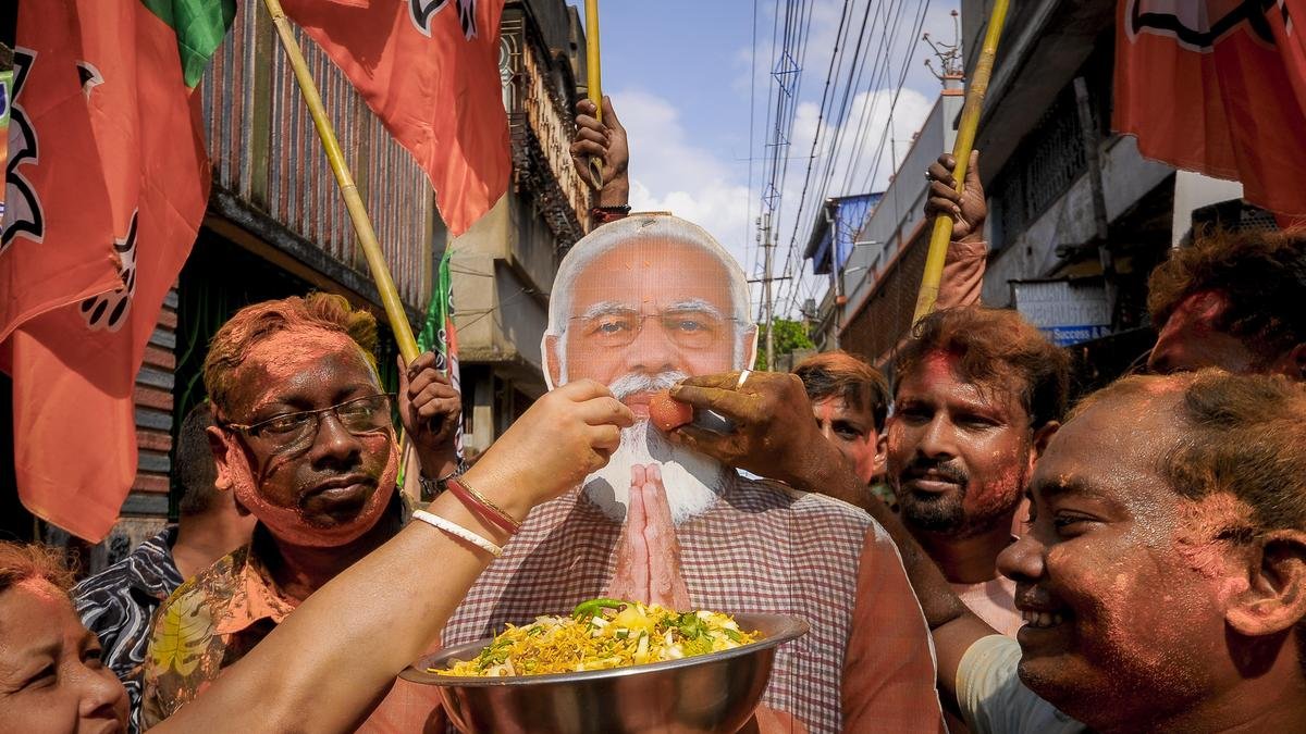 BJP workers offer sweets and jhalmuri to a cutout of Prime Minister Narendra Modi as they celebrate the party's lead in Howrah, on May 4, 2026